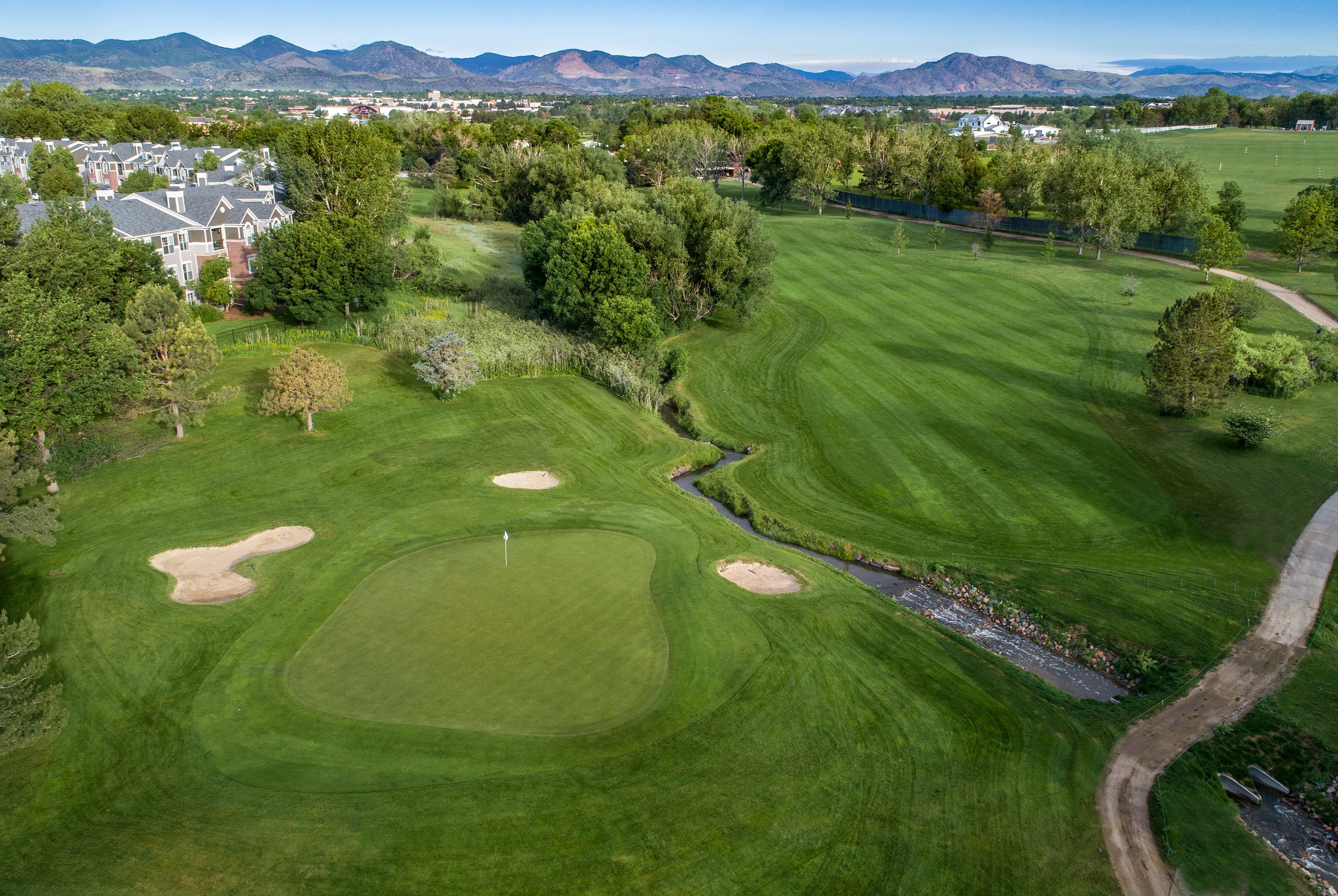 Aerial view of Raccoon Creek showing lake, fairways, and Rocky Mountains